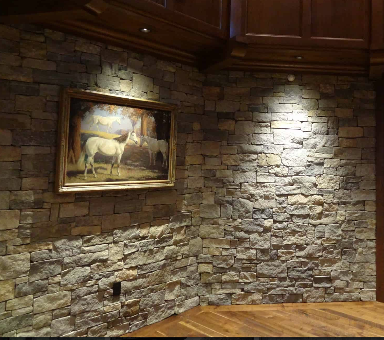 Interior stone veneer accent wall with dramatic uplighting and textured finish